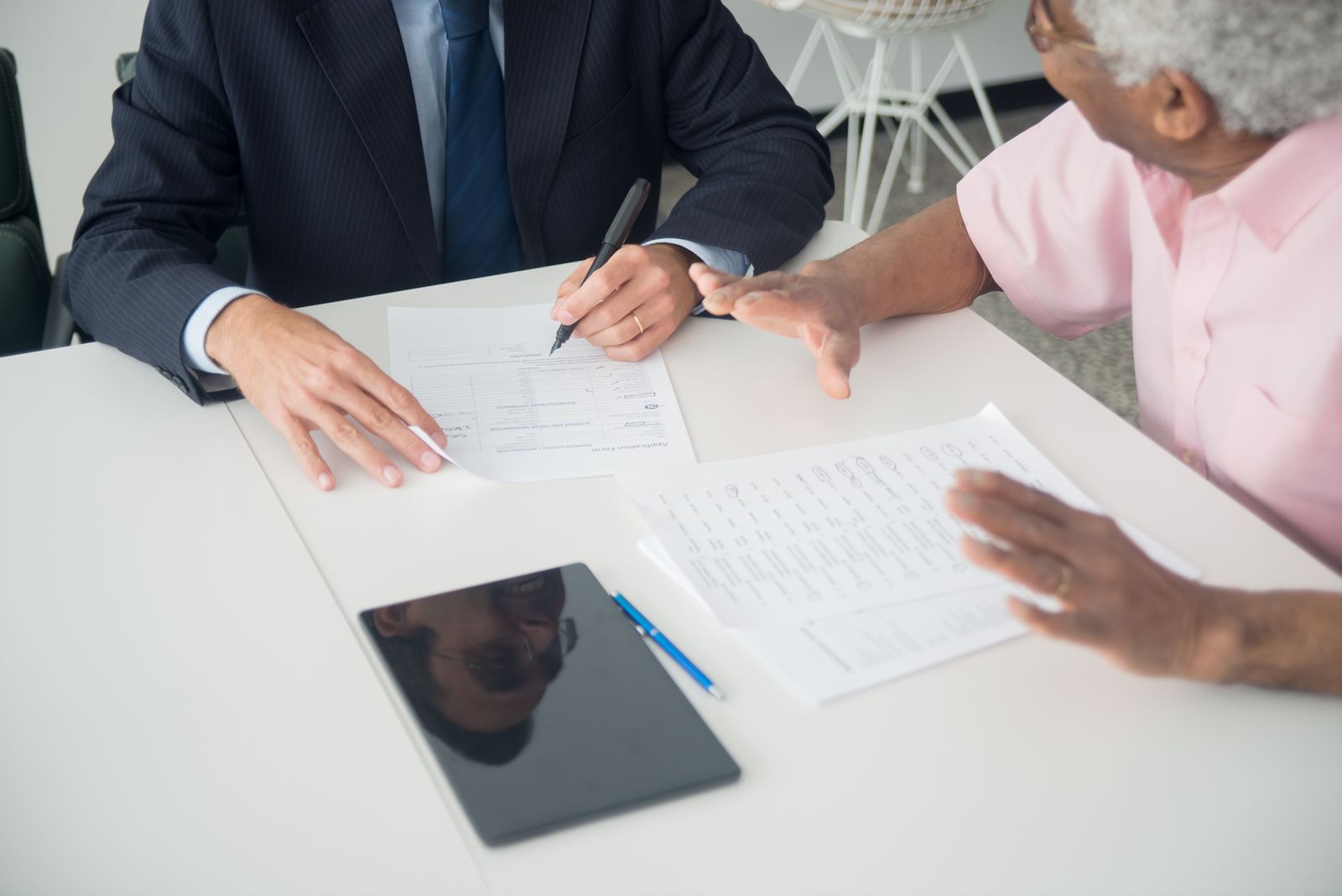 Two people going through paperwork at a kitchen table